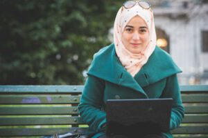 photo of woman in coat with laptop